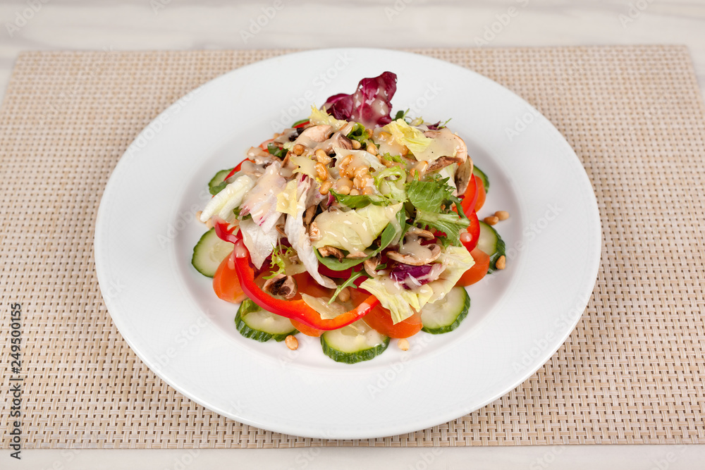 Vegetable salad with corn and mushrooms on a white plate on the table. Vegetable salad with corn and mushrooms on a white plate on the table.