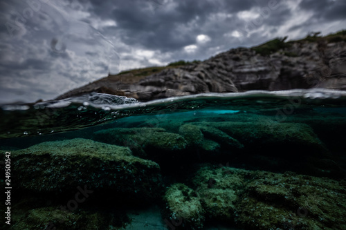 half over half underwater shot on a beautiful bay in Palma de Mallorca, Coast line water line macro shot, underwater photography with a dome port