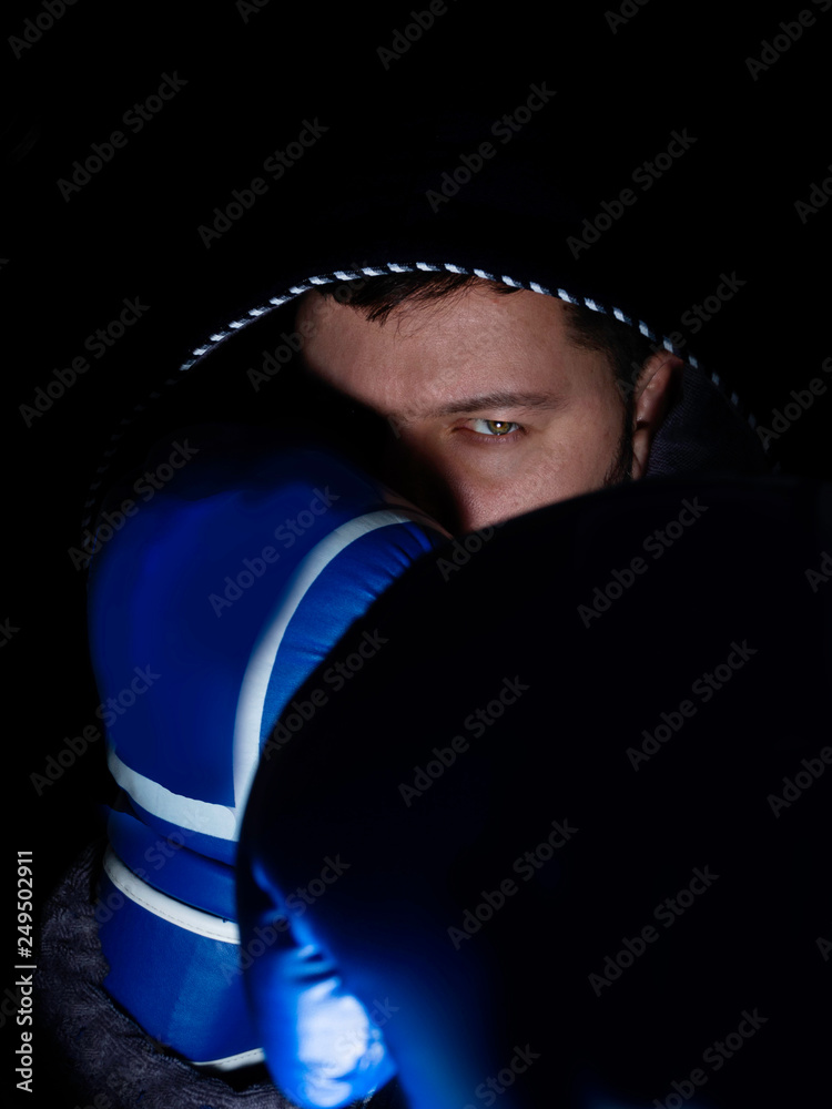 boxer in hood against dark background