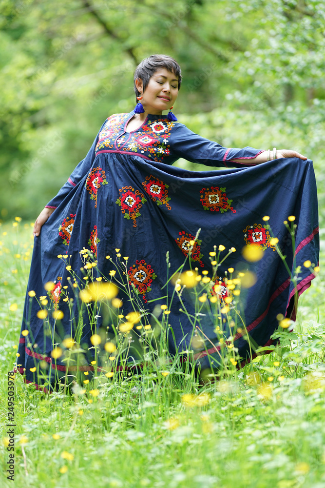 Femme avec robe brodée bleu à fleurs au milieu de l'h Femme avec robe brodée bleu à fleurs au milieu de l'h