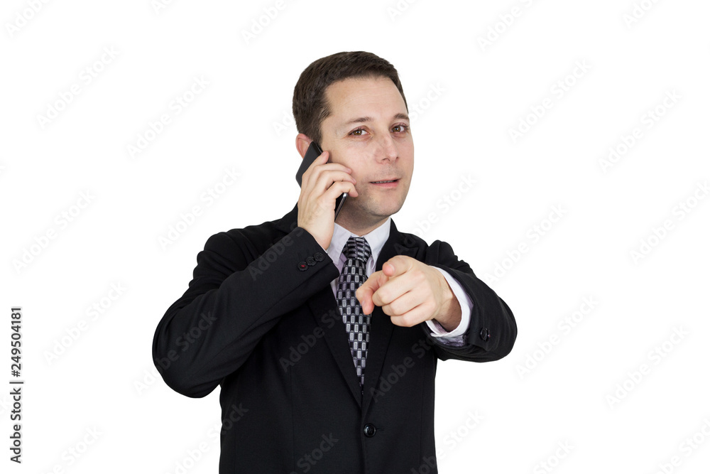 Businessman in Black Suit Talking On The Phone And Pointing Index Finger Towards Camera Against White Background Businessman in Black Suit Talking On The Phone And Pointing Index Finger Towards Camera Against White Background