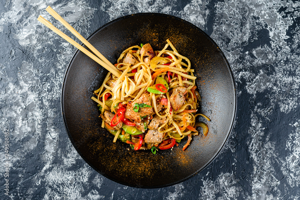 Udon stir-fry noodles with chicken meat and sesame in bowl