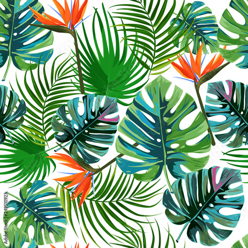 Tropical dark green leaves of palm trees and flowers bird of paradise strelitzia . Summer exotic seamless pattern.