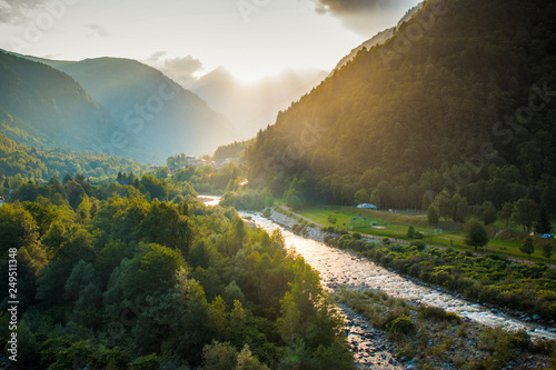 Golden hour on Sesia river valley with sun rays filtering through the clouds. Scopello, Piedmont, Northern Italy. photo