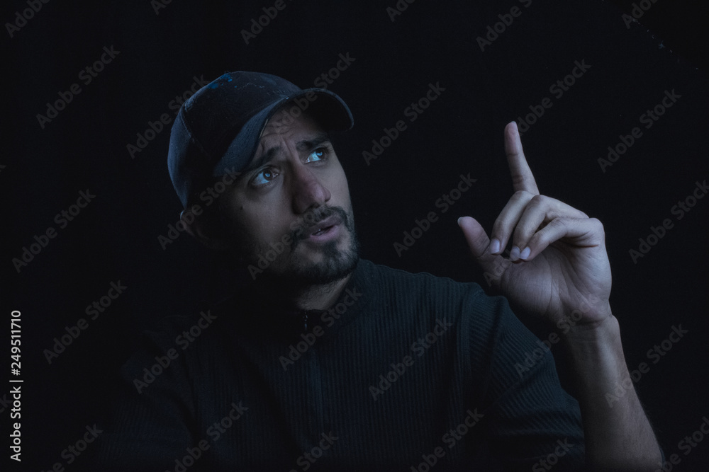 portrait of man in low key making gestures by hand portrait of man in low key making gestures by hand