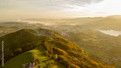 fog overt a city in the beautiful heart of austria with a great hill in the foreground, great sunrise in austria