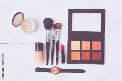 Makeup brush and cosmetics, on a white background.