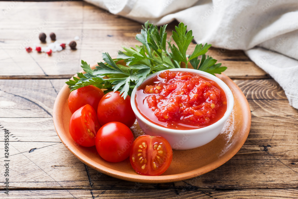 Tomato sauce pasta in a bowl and fresh tomatoes with parsley on a wooden table Tomato sauce pasta in a bowl and fresh tomatoes with parsley on a wooden table