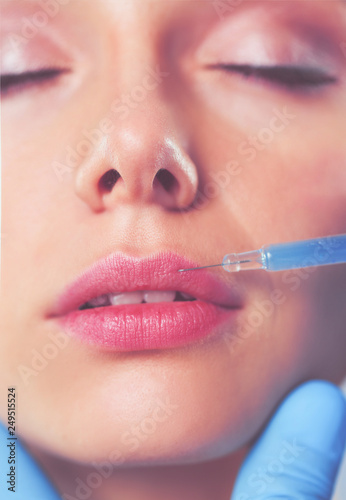 Cosmetic injection on the pretty woman face. Isolated on gray background. Cosmetic injection