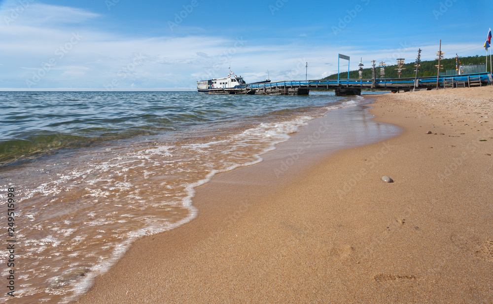 Baikal Lake in summer. Berth for ships near the Khakusy village, wich is famous for hot mineral springs and sandy beaches (translation of the inscription on pier: Have a good trip and stay healthy)