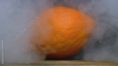 Cucurbita or pumpkin is on the table and smoke or steam blows from behind in slowmo, cloese up photo