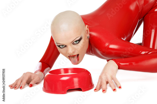 Skinhead woman in red latex catsuit licking milk