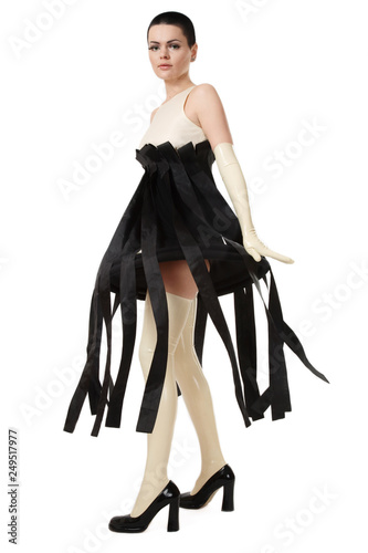 Woman in fancy dress, latex gloves and stockings over white background