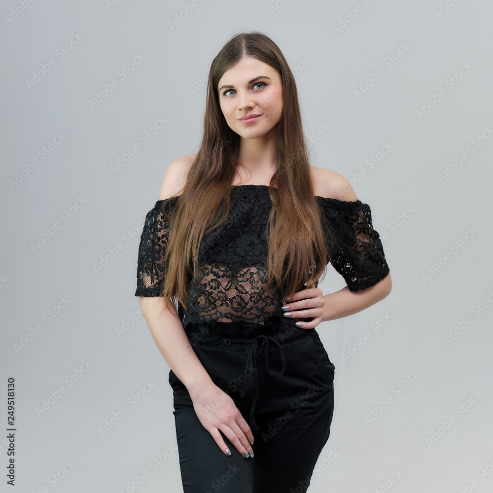 Concept portrait of a pretty beautiful brunette girl talking on a gray background in the studio standing Concept portrait of a pretty beautiful brunette girl talking on a gray background in the studio standing