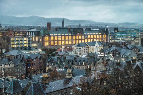 View from above the night city of Edinburgh, rooftops with chimneys, burning windows and the building Edinburgh College of Art. December 2018. United Kigdom photo