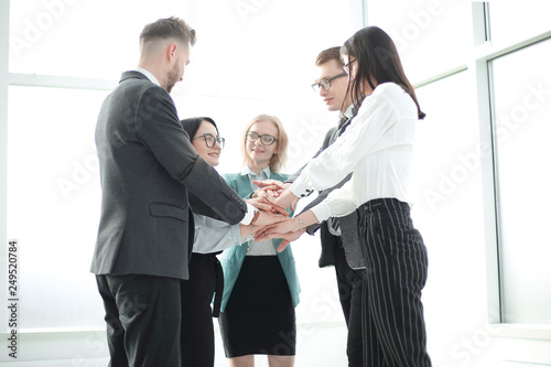 business team showing their unity while standing in the office