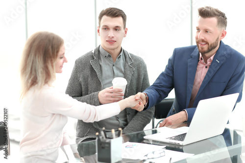 businessman and businesswoman shake hands at a pleasant business meeting.
