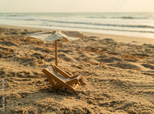 Beach bed and umbrella on the beach with wave of sea