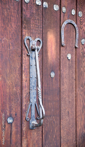 Old decorative door knocker and horseshoe on wooden door , Bulgaria
