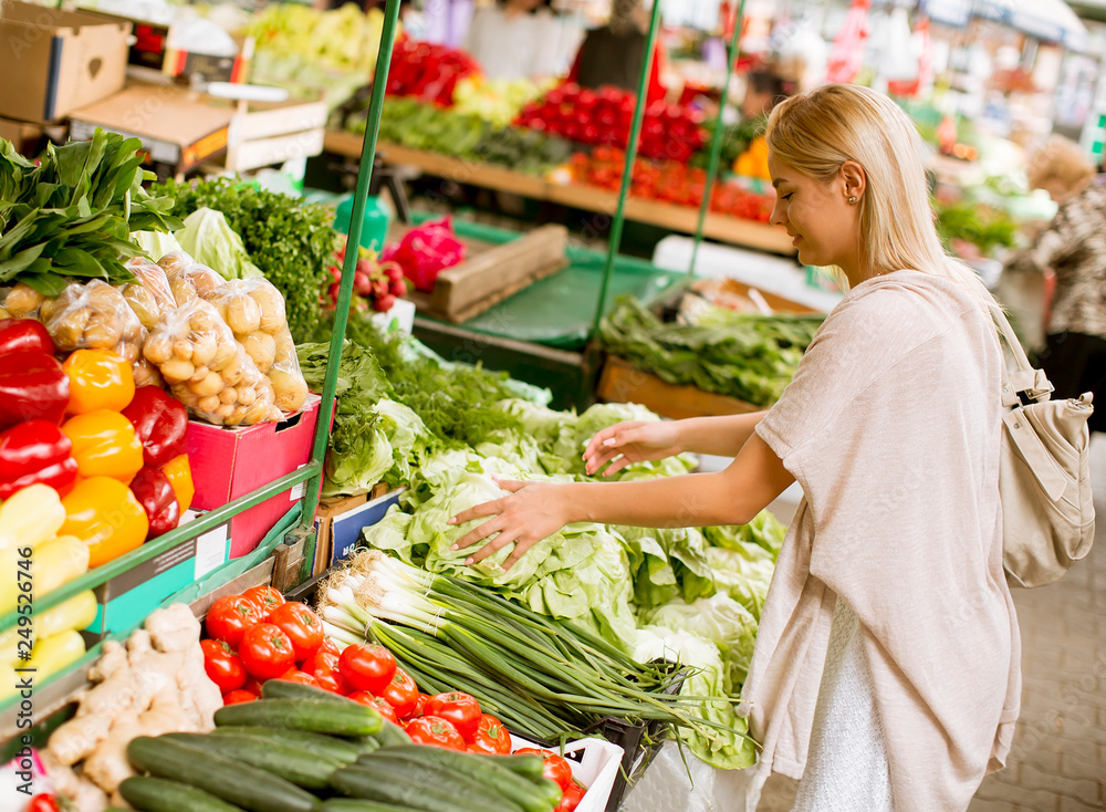 Cute young woman buying vegetables at the market Cute young woman buying vegetables at the market