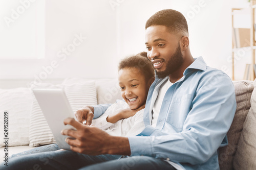 Father and daughter watching movie on tablet