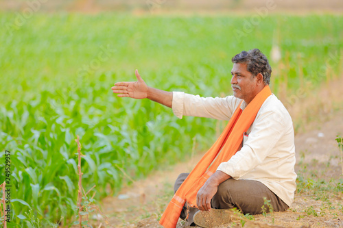 Indian farmer at green corn field