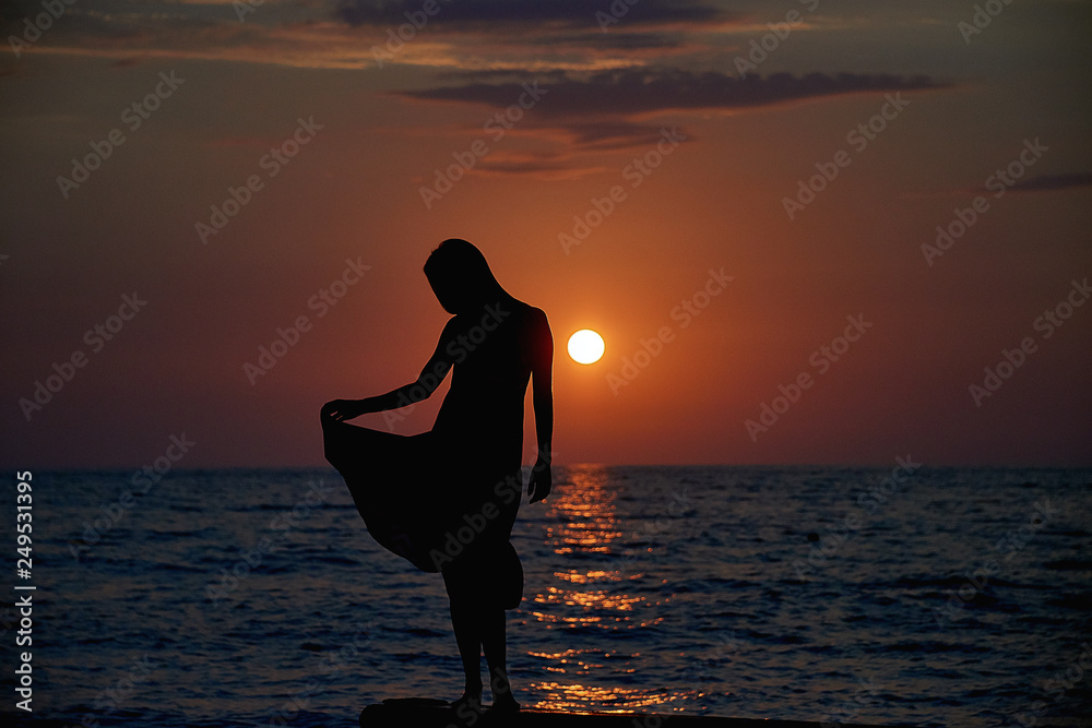 Woman watching sunset on the sea