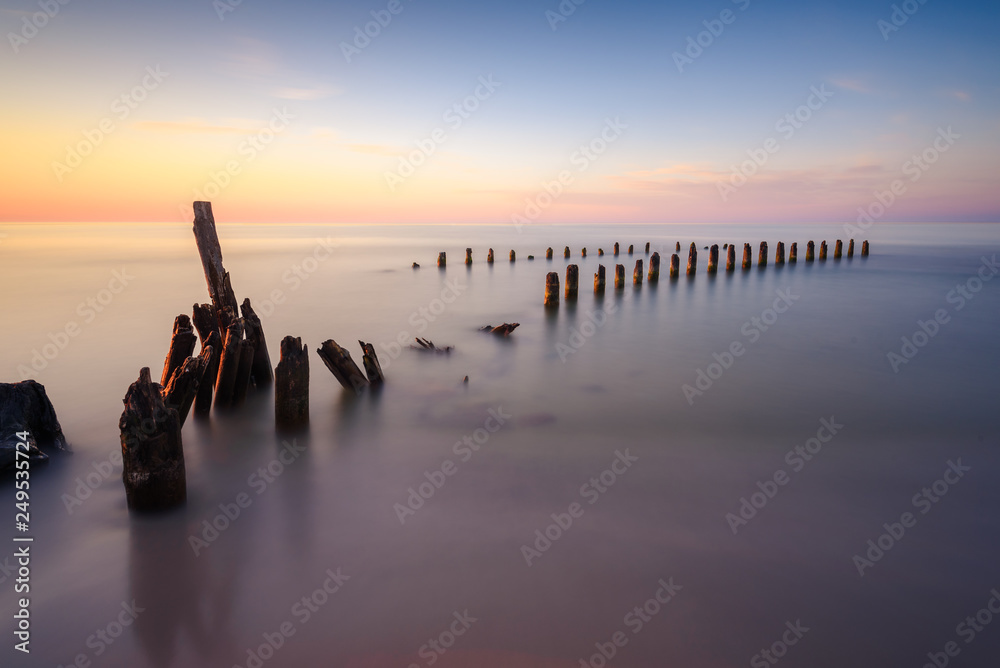 Stakes on the Baltic sea at sunset time, Karwia village, Poland