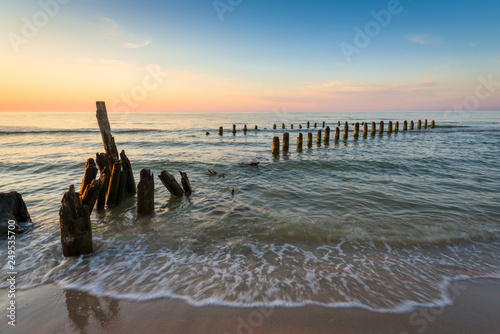 Fototapeta Naklejka Na Ścianę i Meble -  Stakes on the Baltic sea at sunset time, Karwia village, Poland