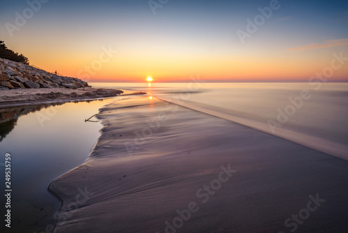 Sunset over Baltic Sea. Sandy beach in Karwia village. Poland