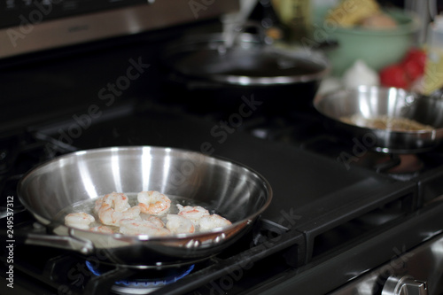 Shrimp cooking in a stainless steel pan on the stove.