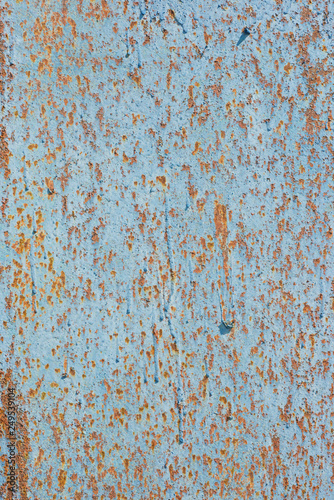 Rusty iron sheet covered by old blue paint. Abstract background