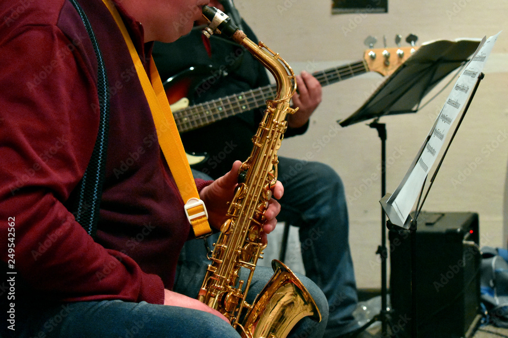 Naklejka premium musicians playing the saxophone and guitar fragment
