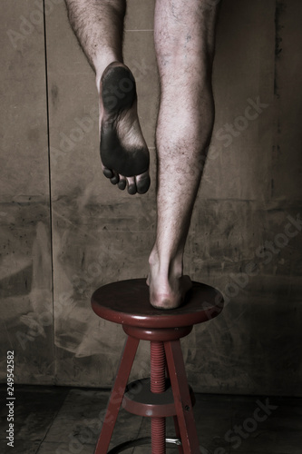 Des pieds sur un tabouret montrant la plante des pieds sale photo