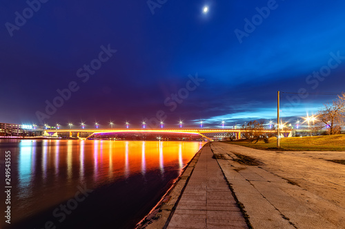 Belgrade, Serbia - February 10, 2019: The Gazela Bridge (Serbian: Most Gazela) is the most important bridge over the Sava river in Belgrade. A panorama of Belgrade by night with reflection in water. © nedomacki