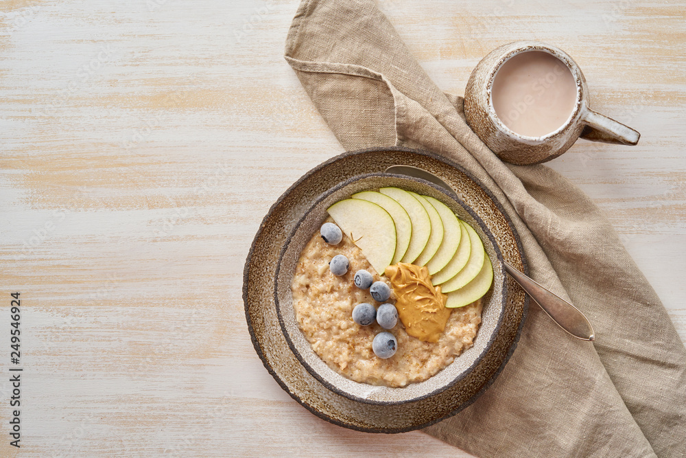 Oatmeal, healthy porridge in large bowl with fruits and berry for breakfast, cup of cocoa. Top view, copy space Oatmeal, healthy porridge in large bowl with fruits and berry for breakfast, cup of cocoa. Top view, copy space