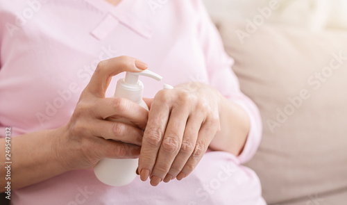 Hands senior woman with moisturizing cream closeup