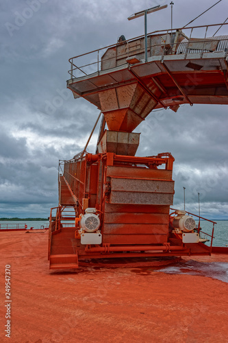Industrial machinery for transhipment of bauxite ore from mining trains to bulk carrier ships. Kamsar, Guinea. photo