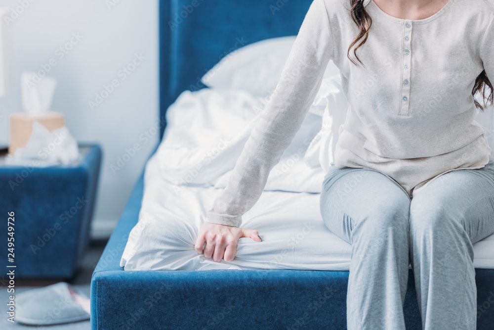 cropped view of woman in pajamas sitting on bed with copy space - obrazy, fototapety, plakaty 