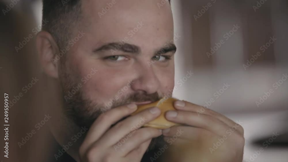 Young hungry funny man and woman eating burgers in cafe. 4K Young hungry funny man and woman eating burgers in cafe. 4K