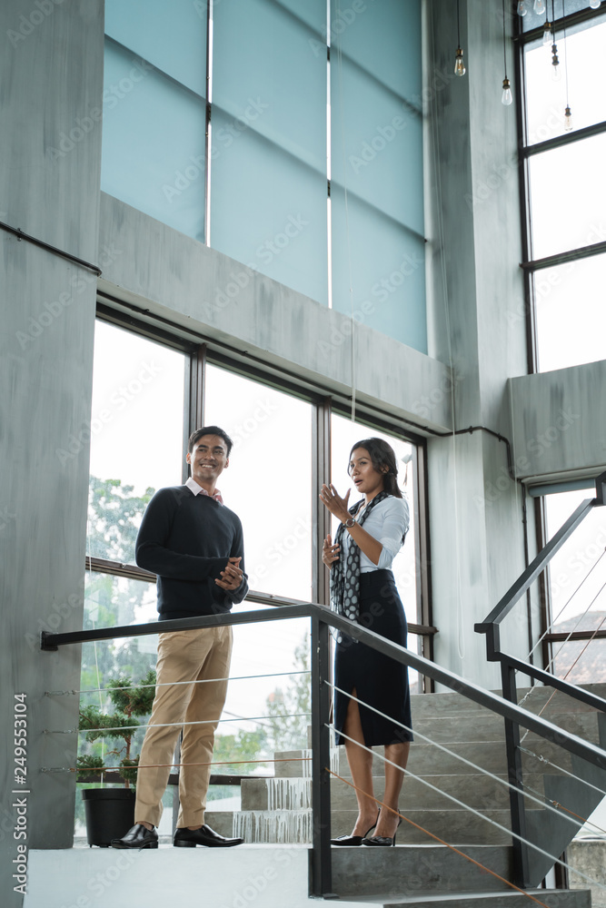 business people walking on stairs in the office and chatting