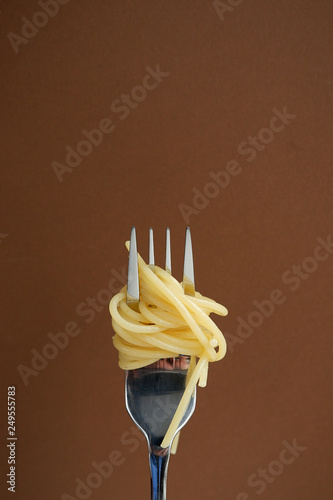 Pasta on a fork. Brown background