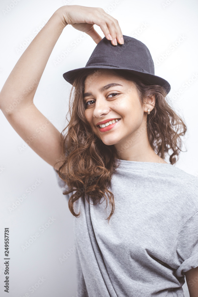 Smiling brunette in a black hat. Portrait of a happy young woman on a white background. Smiling brunette in a black hat. Portrait of a happy young woman on a white background.
