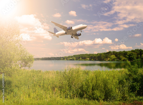 Air plane over the lake and green forest the sun is shining.