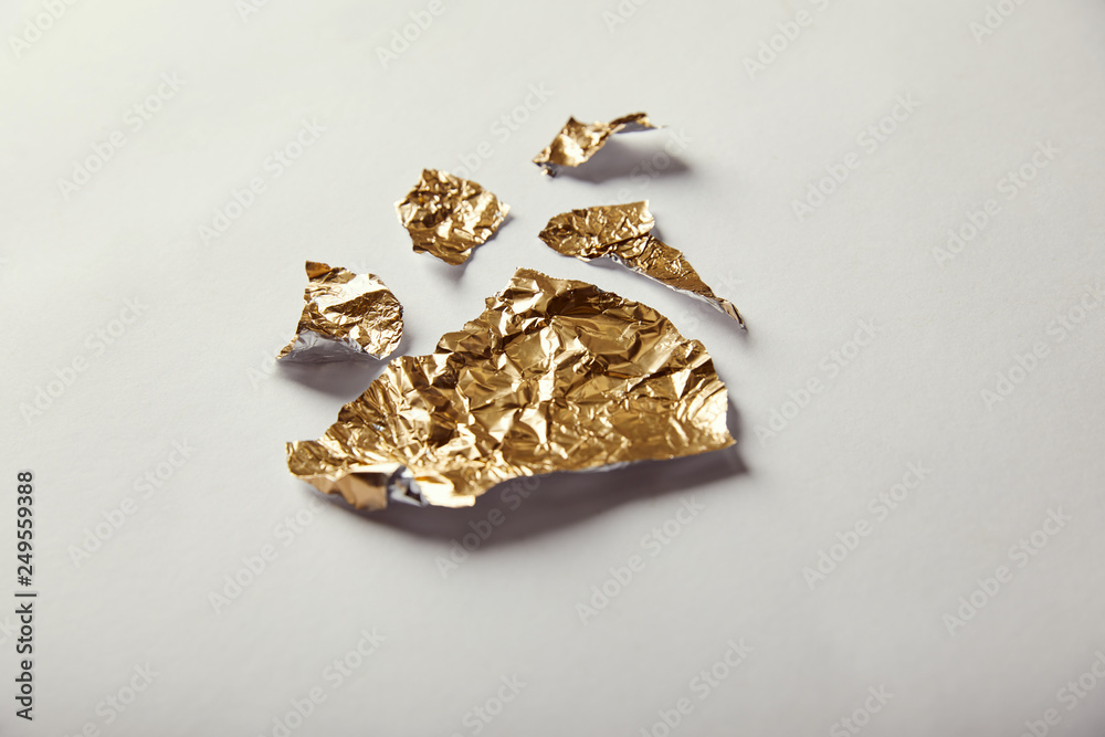 pieces of golden foil on white background pieces of golden foil on white background