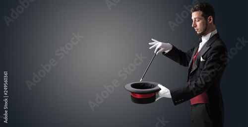 Leinwand Poster Illusionist white hand wants to conjure with magic wand from a black cylinder so