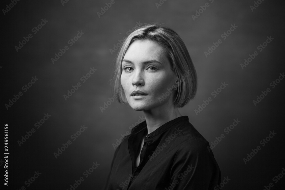 Fototapeta premium Dramatic black and white portrait of a beautiful woman on a dark background
