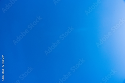 Clear blue sky empty with a sun reflection on one side - empty space for design