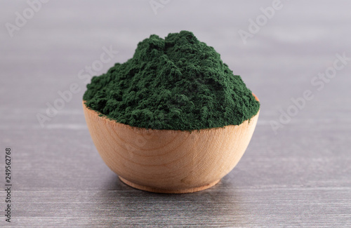 Bowl of Spirulina Powder on a Wooden Table