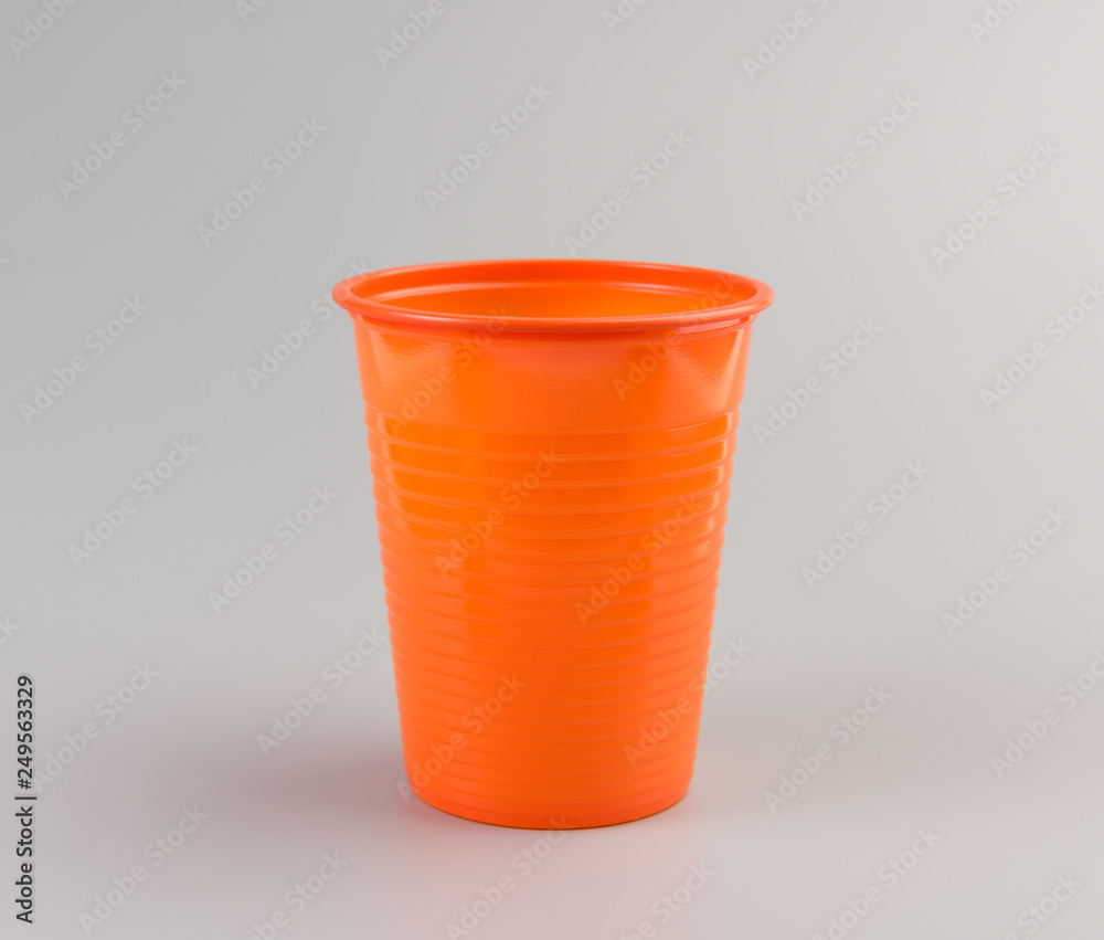 Round orange Plastic Cup isolated on grey background Round orange Plastic Cup isolated on grey background